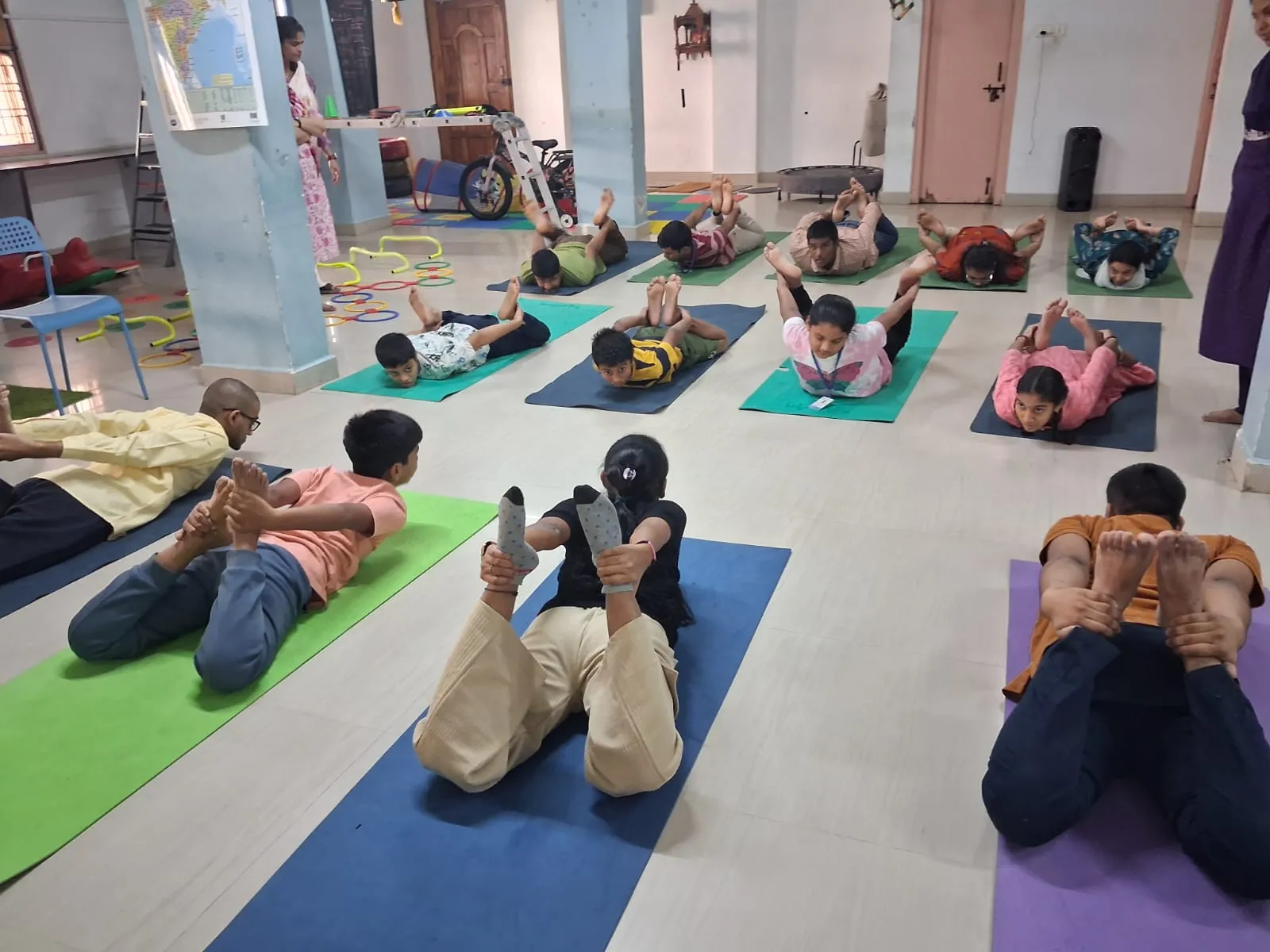 Children doing yoga on mats in the activity room